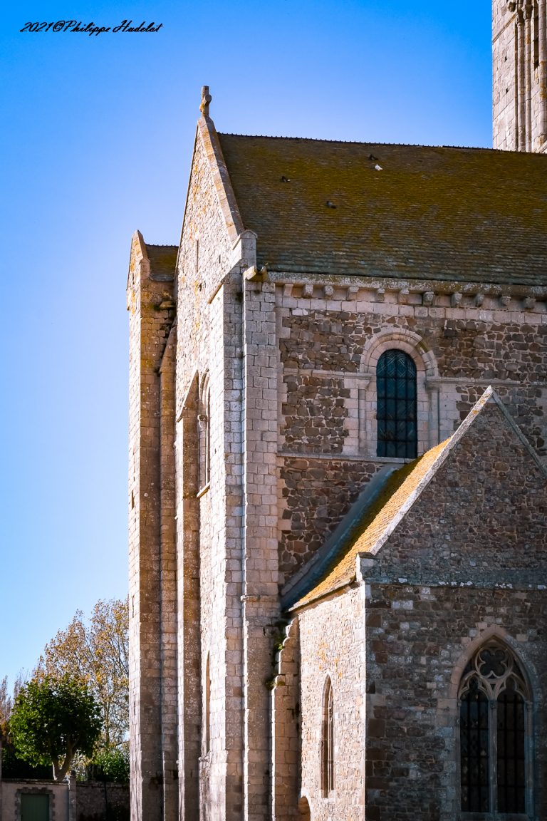 Vue de l'Abbaye de la Sainte-Trinité de Lessay, son architecture romane et son cadre naturel.