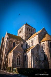 Vue de l'Abbaye de la Sainte-Trinité de Lessay, son architecture romane et son cadre naturel.